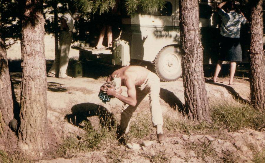 Camp just short of Herat. Uncle Bob fixing breakfast at the rear of Bucephalus, whilst Valerie attends to her hair and I have a wash in the irrigation channel